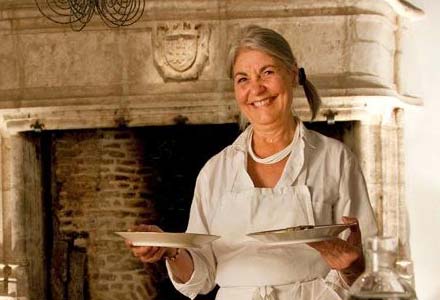 Claude Mitrani servant ses invités dans salle à manger de FOUR maison d'hotes, dans le village de Montcuq en Quercy Blanc.